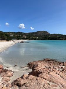 a beach with people walking on the sand and the water at Holiday House in Villa Beatrice in Porto Istana