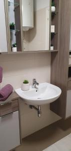 a bathroom with a white sink and a mirror at Apartment JASS next to MALL OF SPLIT in Split
