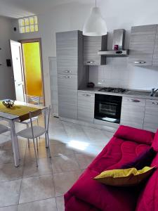 a living room with a red couch and a table at Casa Vacanze Happy Home in Zafferana Etnea +11 photos