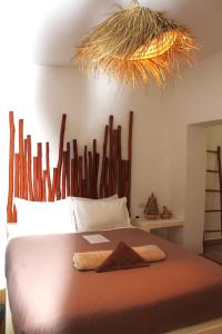 a bedroom with a large bed with a wooden headboard at La Maison des Vagues in Sidi Kaouki