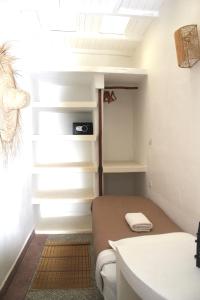 a small room with a bed and a sink at La Maison des Vagues in Sidi Kaouki