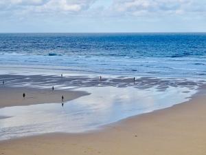 a group of people walking on the beach at Fairways Guest House in Newquay +76 photos