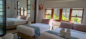 a room with two beds and a couch and windows at Celine Pool Villa Cha-Am in Cha Am +92 photos