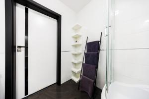 an open door leading to a bathroom with purple towels at Apartamenty Zamkowe- High Standard Apartment City Center by StayNest in Rzeszów +11 photos