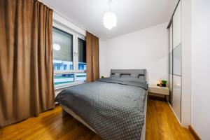 a bedroom with a bed and a large window at Apartamenty Zamkowe- High Standard Apartment City Center by StayNest in Rzeszów