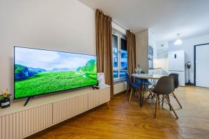 a living room with a large flat screen tv on a wall at Apartamenty Zamkowe- High Standard Apartment City Center by StayNest in Rzeszów