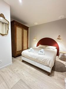 a bedroom with a bed with two towels on it at La Nichée appartement 2 chambres in Trévoux