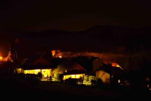 una casa ardiendo de noche con llamas en Alpejskie Domy Ski House en Krynica Zdrój