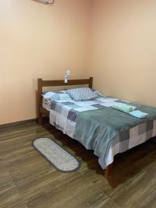 a bedroom with a bed and a rug on the floor at Casa Maria Alice in Manhã
