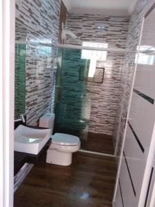 a bathroom with a white toilet and a sink at Casa Maria Alice in Manhã +9 photos