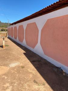 a white and pink wall with a roof at Casa Maria Alice in Manhã +9 photos