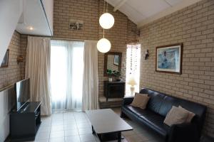 un soggiorno con un divano e una TV di Kustverhuur, Park Schoneveld, Strandparel 365 a Breskens