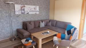 un salon avec un canapé, une table et des chaises dans l'établissement Ferienwohnung Sonja Sinsheim, à Sinsheim