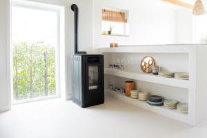 a kitchen with a black refrigerator and plates on shelves at By Tons Huisje inclusief twee fietsen in Zegveld