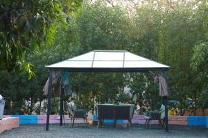 a table and chairs under a canopy in a park at Heeran Re-Treat Resort in Sasan Gir