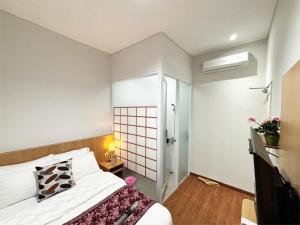 a hotel room with a bed and a bathroom at Florens Inn in Yogyakarta