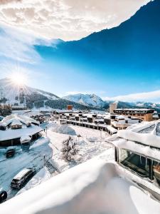 a city covered in snow with mountains in the background at Hostdomus - Urban Villa in Sestriere