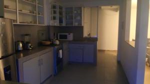 Una cocina con gabinetes azules y un microondas. en Casa EN ASIA, en Asia