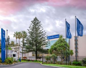 una señal para un hotel con un árbol delante de un edificio en Garden Court East London, en East London
