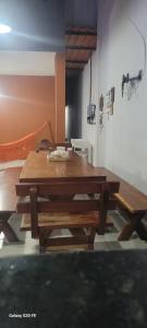 a dining room with a wooden table and benches at casa sol e mar 01 in Paripueira