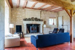 a living room with a blue couch and a fireplace at Maison de campagne sud Touraine avec piscine 8px in Crouzilles