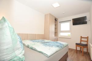 ein Schlafzimmer mit einem Bett und einem Fernseher an der Wand in der Unterkunft Ferienhaus Fuchswinkel in Güntersberge