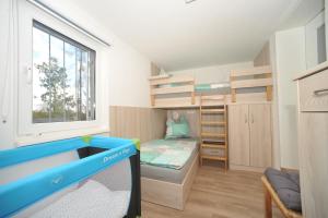 Kleines Zimmer mit einem Etagenbett und einem TV. in der Unterkunft Ferienhaus Fuchswinkel in Güntersberge + 9 Fotos