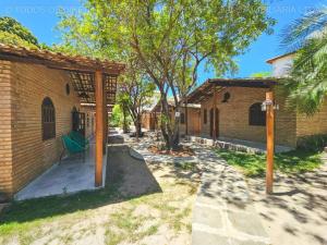 a backyard with a brick building and a green chair at Chalés de Imbassaí - Chalé 4 in Mata de Sao Joao