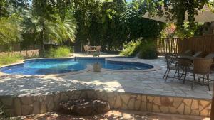 a patio with a pool and a table and chairs at Chalés de Imbassaí - Chalé 4 in Mata de Sao Joao