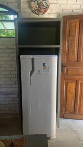 a white refrigerator in a room next to a door at Chalés de Imbassaí - Chalé 4 in Mata de Sao Joao