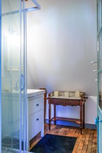 a bathroom with a glass shower and a table at Maison de charme en Touraine avec jardin 4 p. in Luynes