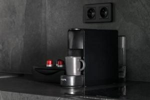 a coffee cup sitting on top of a counter at Kairos Apartments - Manhattan Premium-klimatyzacja-siłownia-sala kinowa in Katowice