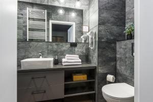 a bathroom with a sink and a toilet at Kairos Apartments - Manhattan Premium-klimatyzacja-siłownia-sala kinowa in Katowice +32 photos