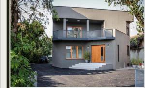 a house with a balcony on top of it at Oasis Airport Apartments and Rooms in Velika Gorica