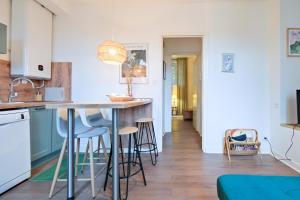 Una cocina con encimera y taburetes en una habitación. en Séjour Cosy, Périgueux, en Périgueux