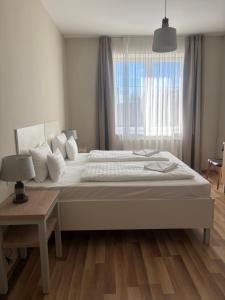 马特劳森蒂姆赖Selfness Hotel Vadvirág Mátraszentimre的一间带大床和窗户的白色卧室