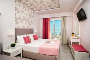 a bedroom with a large bed with a pink blanket at Lafeyra Hotel in Limenaria +53 photos