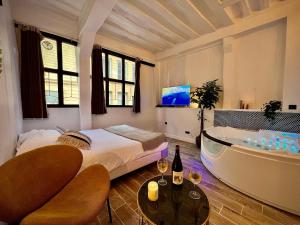 a bedroom with a bathtub and a bed and a bath tub at Le Spa Corneille - Jacuzzi, Sauna & Parking par Rouen Atypique in Rouen