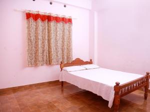 a bedroom with a bed and a window at Royal Residency Apartment in Mundakāyam