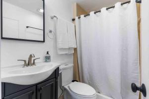 ein Badezimmer mit einem Waschbecken und einem weißen Duschvorhang in der Unterkunft Luxury Living - Kirkland Stylish Home - Prime Spot in Kirkland