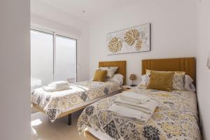 two beds in a room with white walls at Villa La Vida in Santiago de La Ribera in San Javier +11 photos