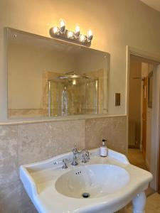a bathroom with a white sink and a mirror at The Old Hunting Lodge at The Talbot Inn in Tenbury +71 photos