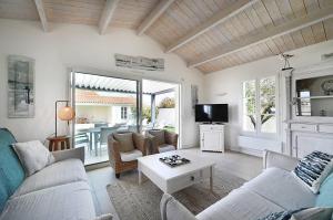 ein Wohnzimmer mit Sofa und Tisch in der Unterkunft Villa Coraly - piscine chauffée et jardin in Sainte-Marie-de-Ré