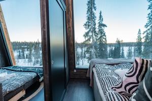 due letti in una stanza con una grande finestra di Lights of Lapland Resort a Posio Altre 4 foto