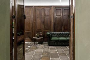 a room with a green couch and a table at Goldenstern Townhouse in Bolzano