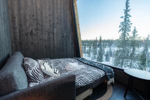 un letto in una camera con una grande finestra di Lights of Lapland Resort a Posio