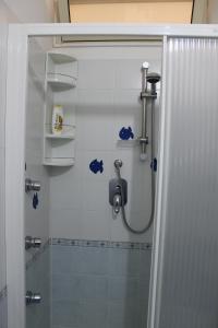 une salle de bain avec une douche avec une porte vitrée dans l'établissement Villa Terry, à Catona