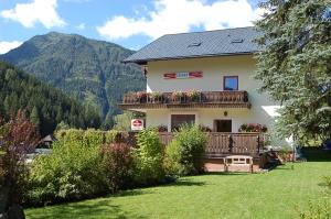 a house with a balcony with flowers on it at Alpengasthof Grobbauer in Rottenmann