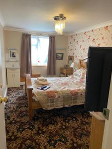 ein Schlafzimmer mit einem Bett und einem Tisch und einem Fenster in der Unterkunft Barons Court in Great Yarmouth