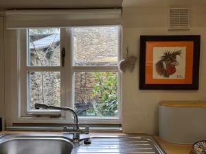 eine Küchenspüle mit einem Fenster in der Küche in der Unterkunft St Antony's Cottage in Stow on the Wold